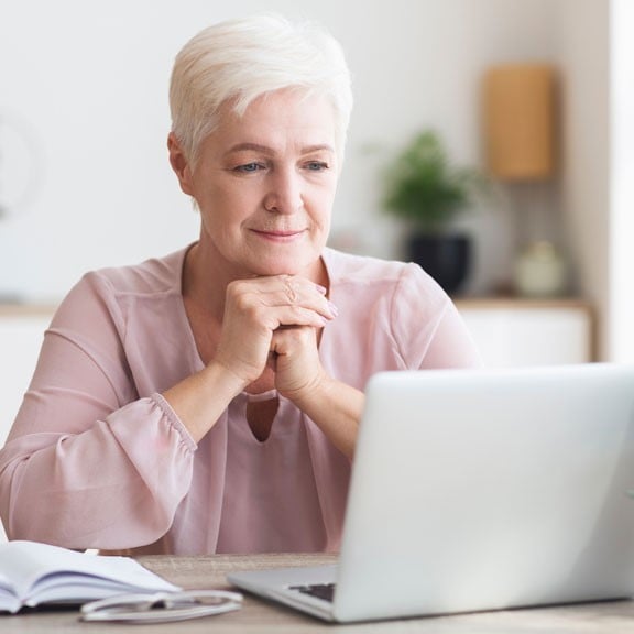 A lady sits at her laptop